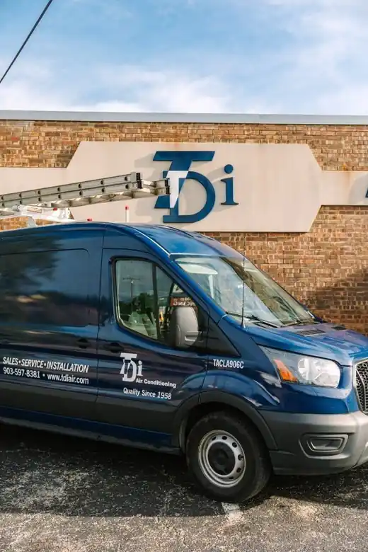 A TDi van parked beneath the TDi Air Conditioning wall sign on the TDi shop