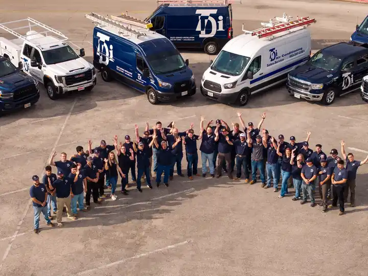 The whole TDi crew waving in an arc in front of the fleet, seen from above