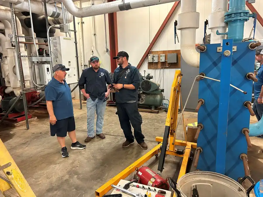 Three TDi staff talking in a commercial mechanical room