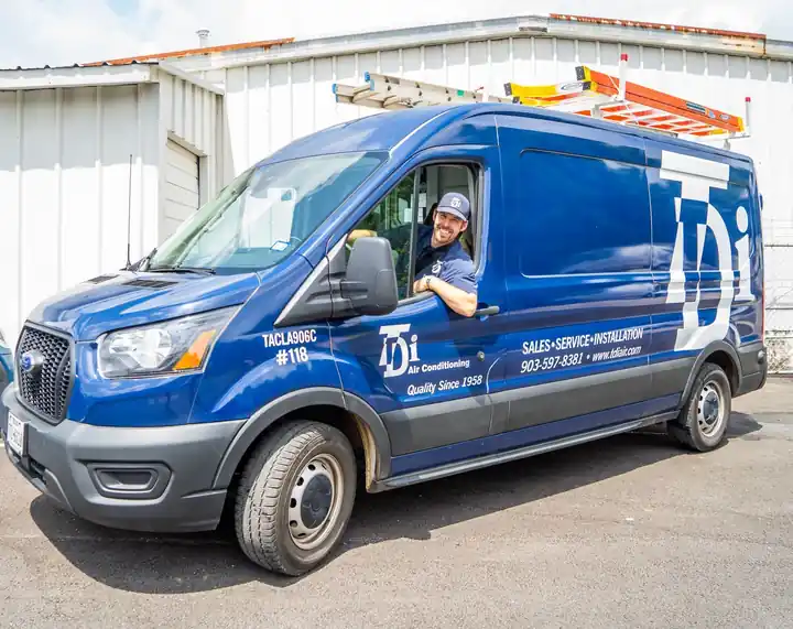 TDi technician in the driver seat of a branded van